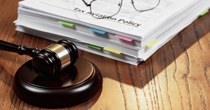 Gavel beside a thick stack of documents labeled “Tax Aviation Policy.”